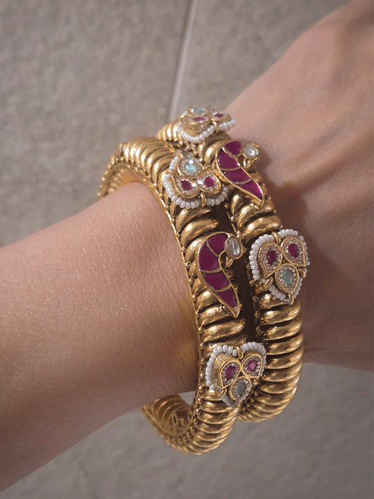 Set of two openable gold plated katas with peacock and three leaf ruby and aqua tukdies