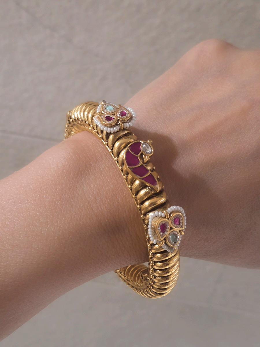 Set of two openable gold plated katas with peacock and three leaf ruby and aqua tukdies