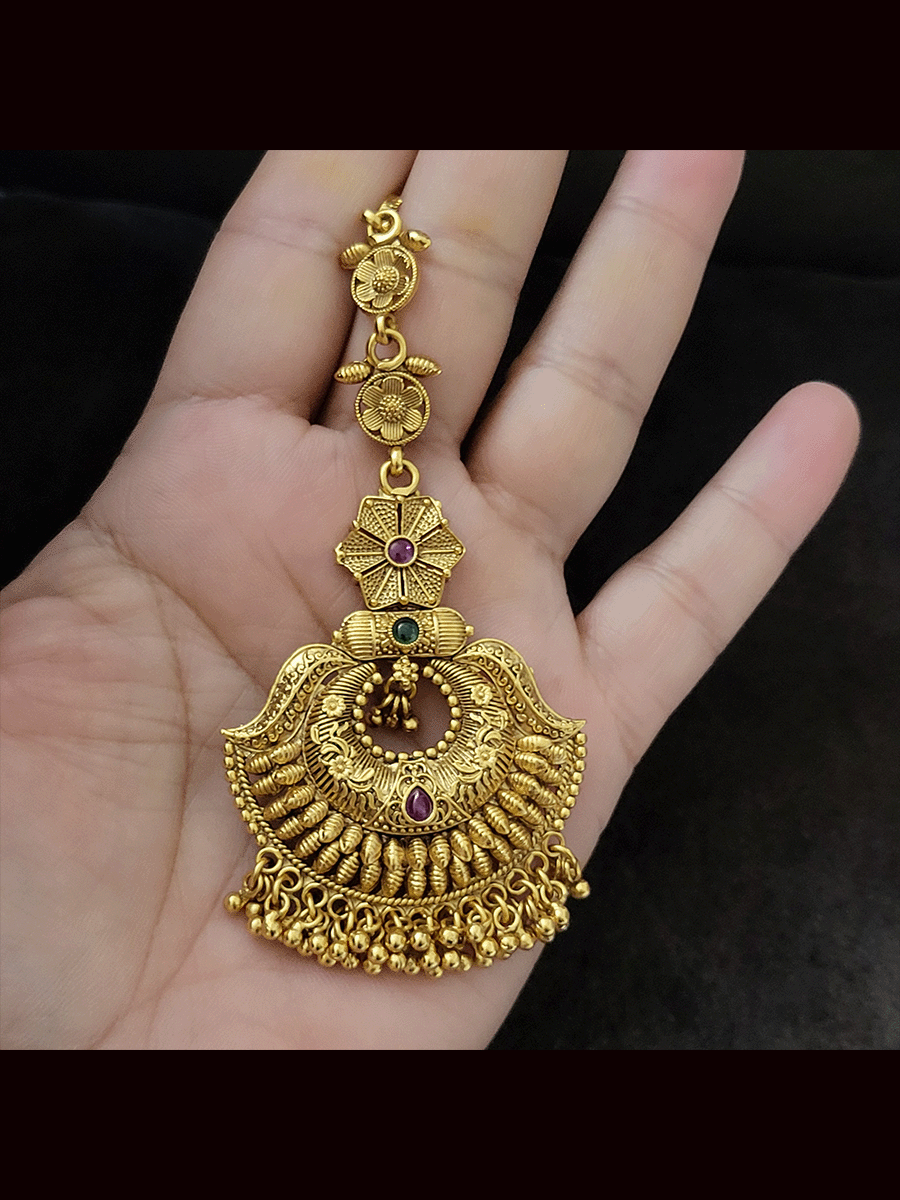 Circular center self design ruby and green stone maangtika with ghunghru hanging