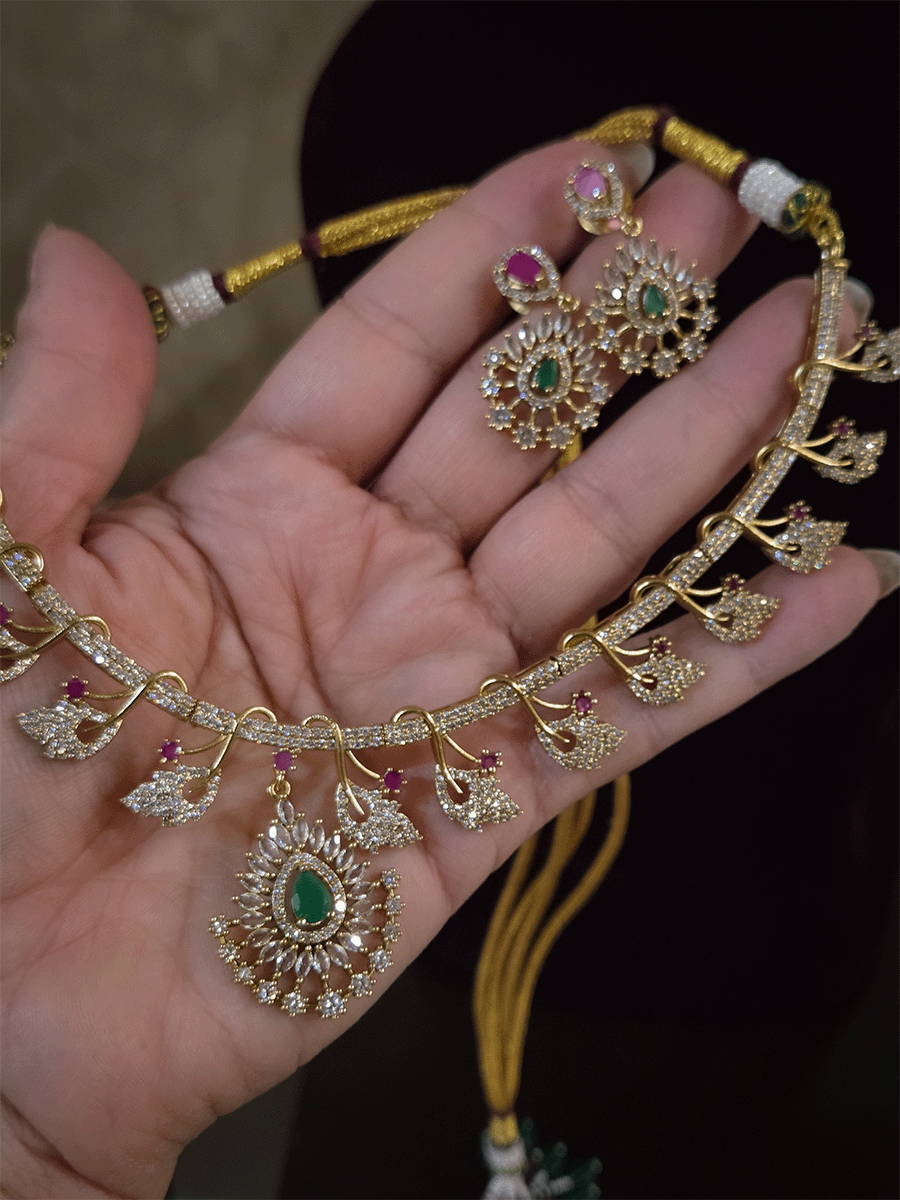 Zircon studded leaf design set with tear drop shaped green stone center hanging tukdi