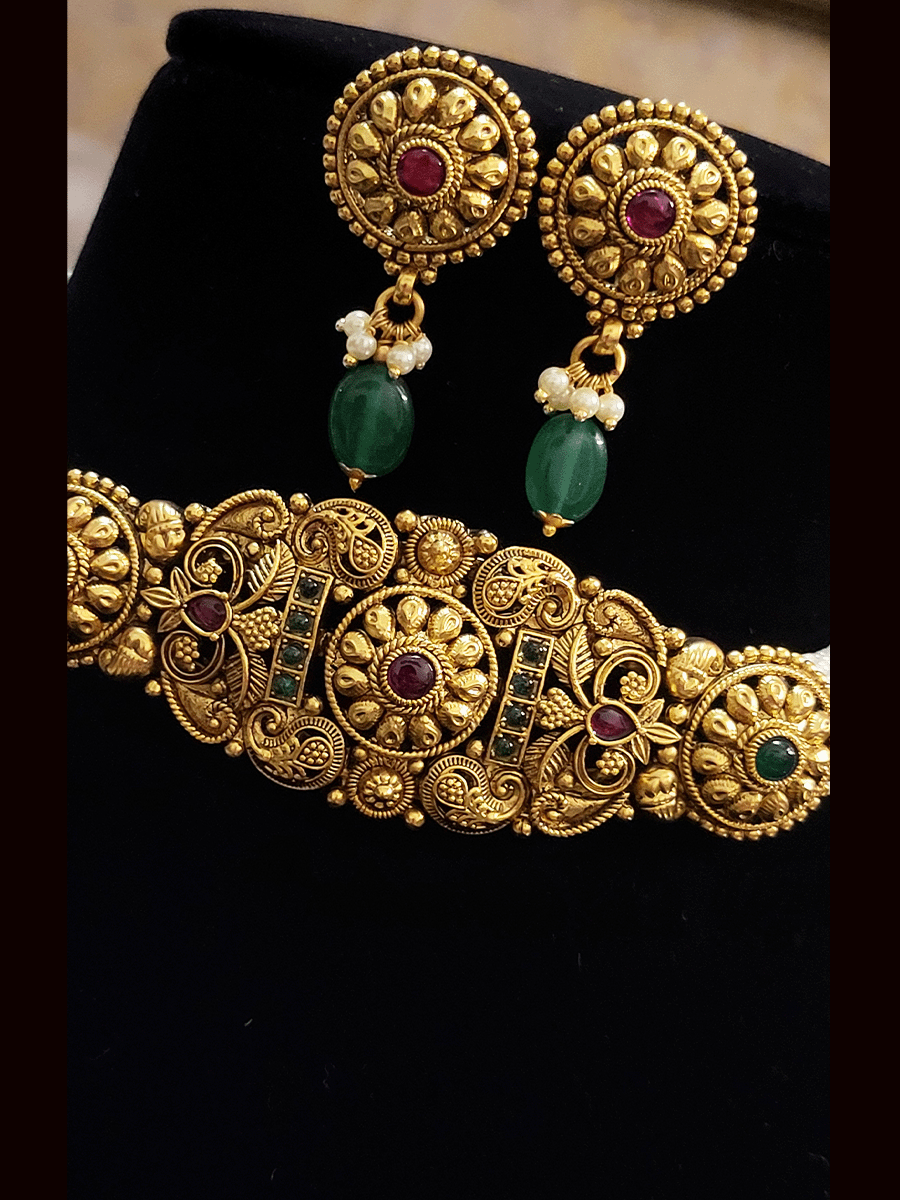 Intricate design ruby and green stones center circular design set with side cheed strings