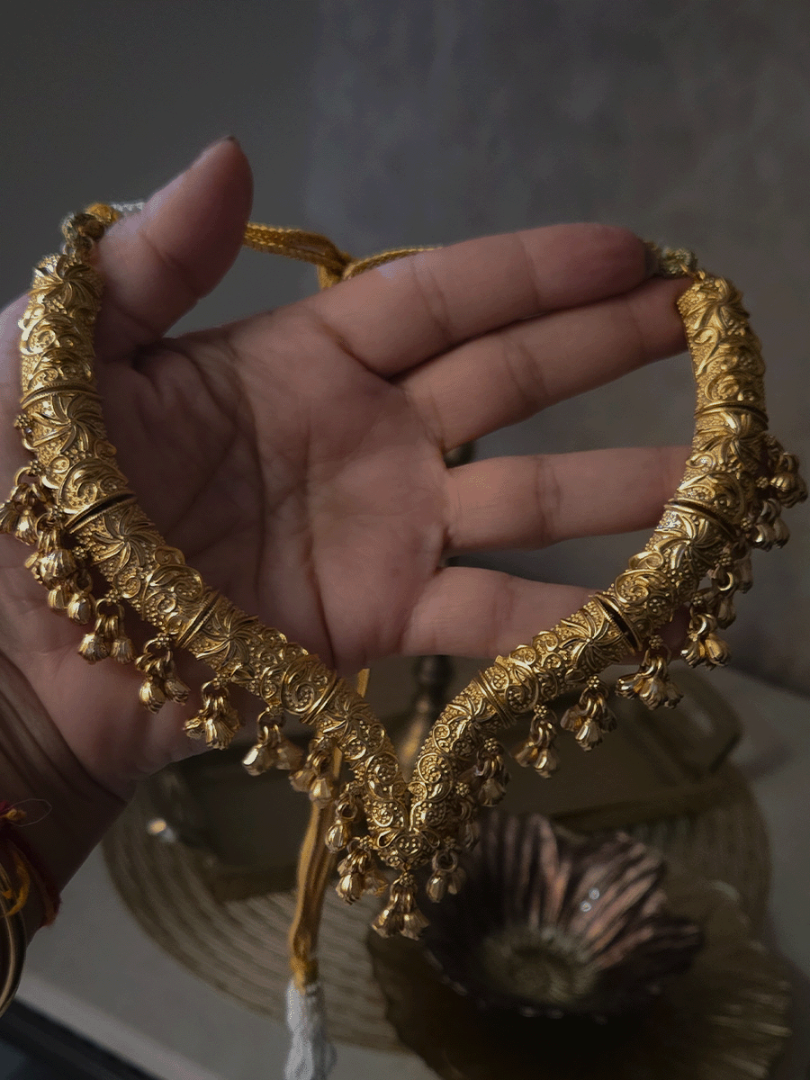Gold finish self design hasli neckpiece with ghunghru hangings