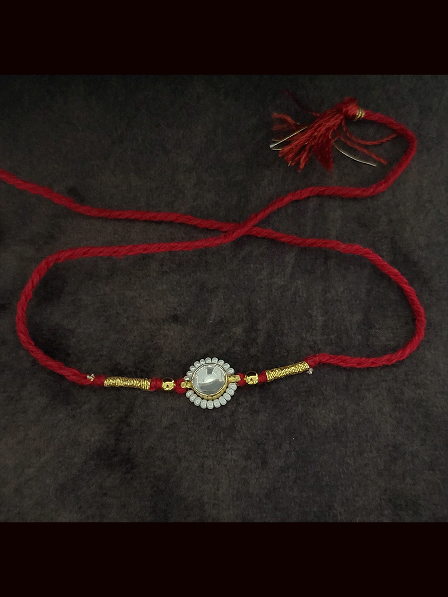 Round stone pirohi work rakhi with two gold beads on sides