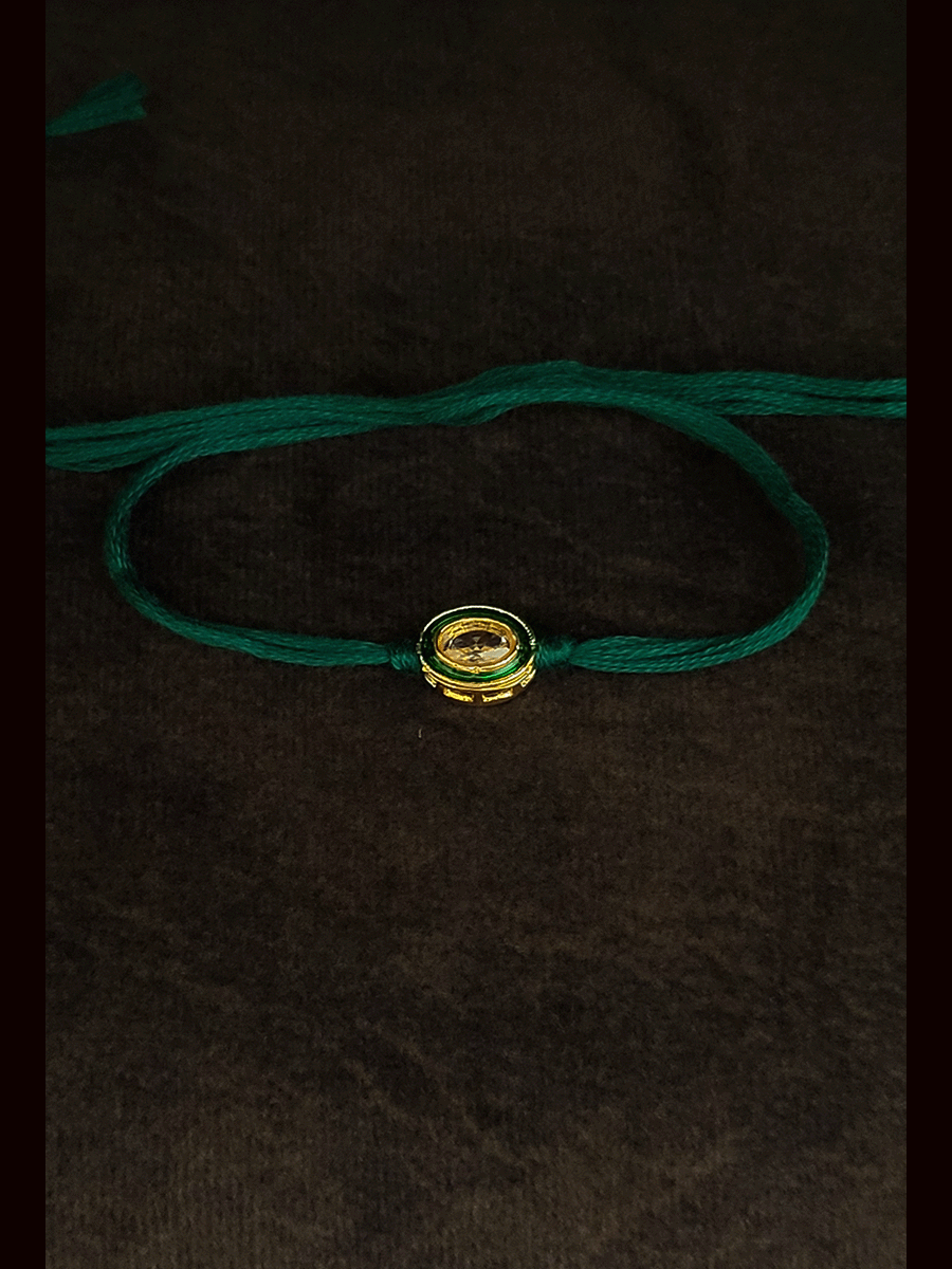 Oval brown stone with green enamel outline with green thread bhai rakhi