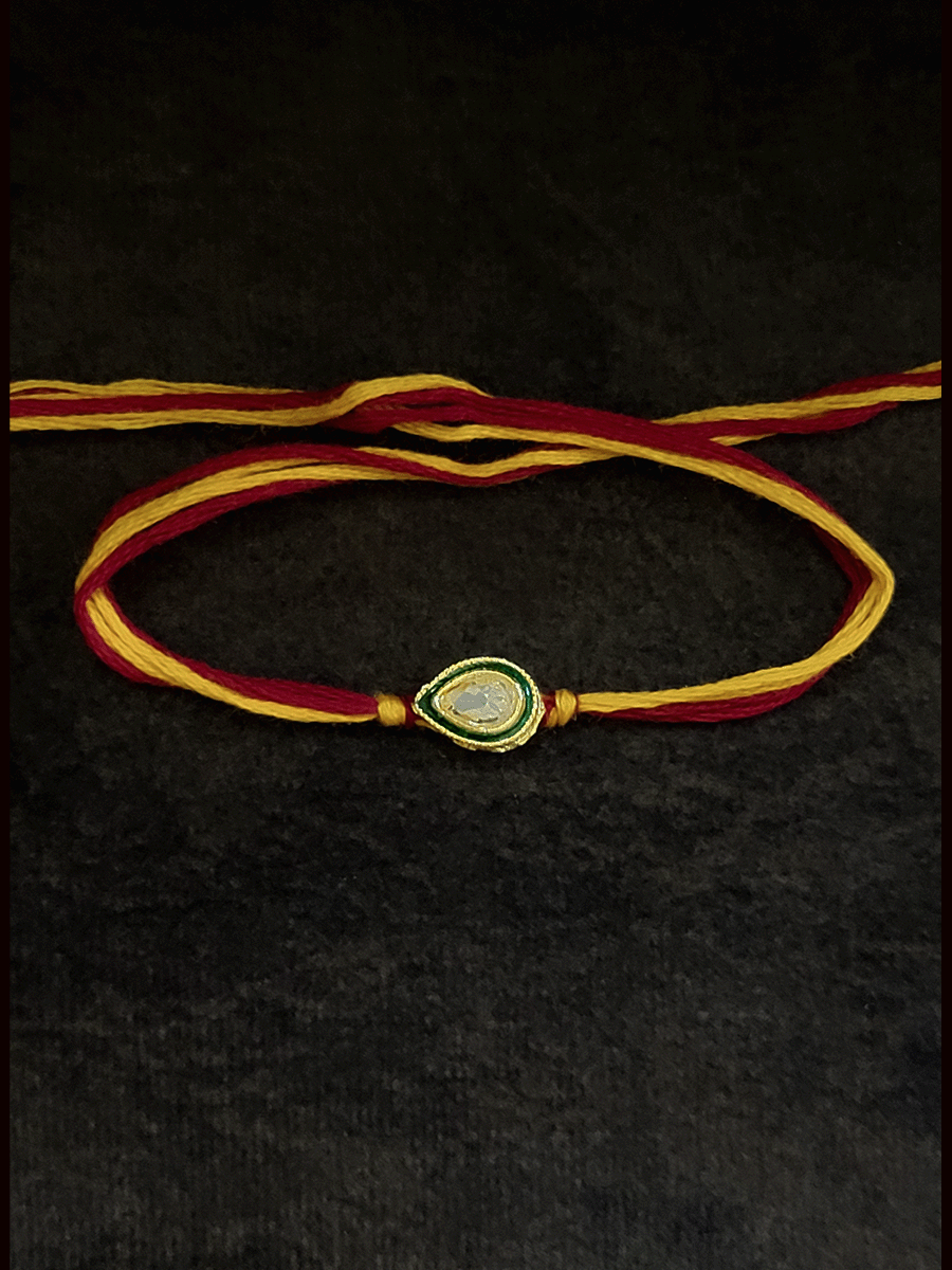 Leaf shaped brown stone with green enamel outline bhai rakhi in mauli thread