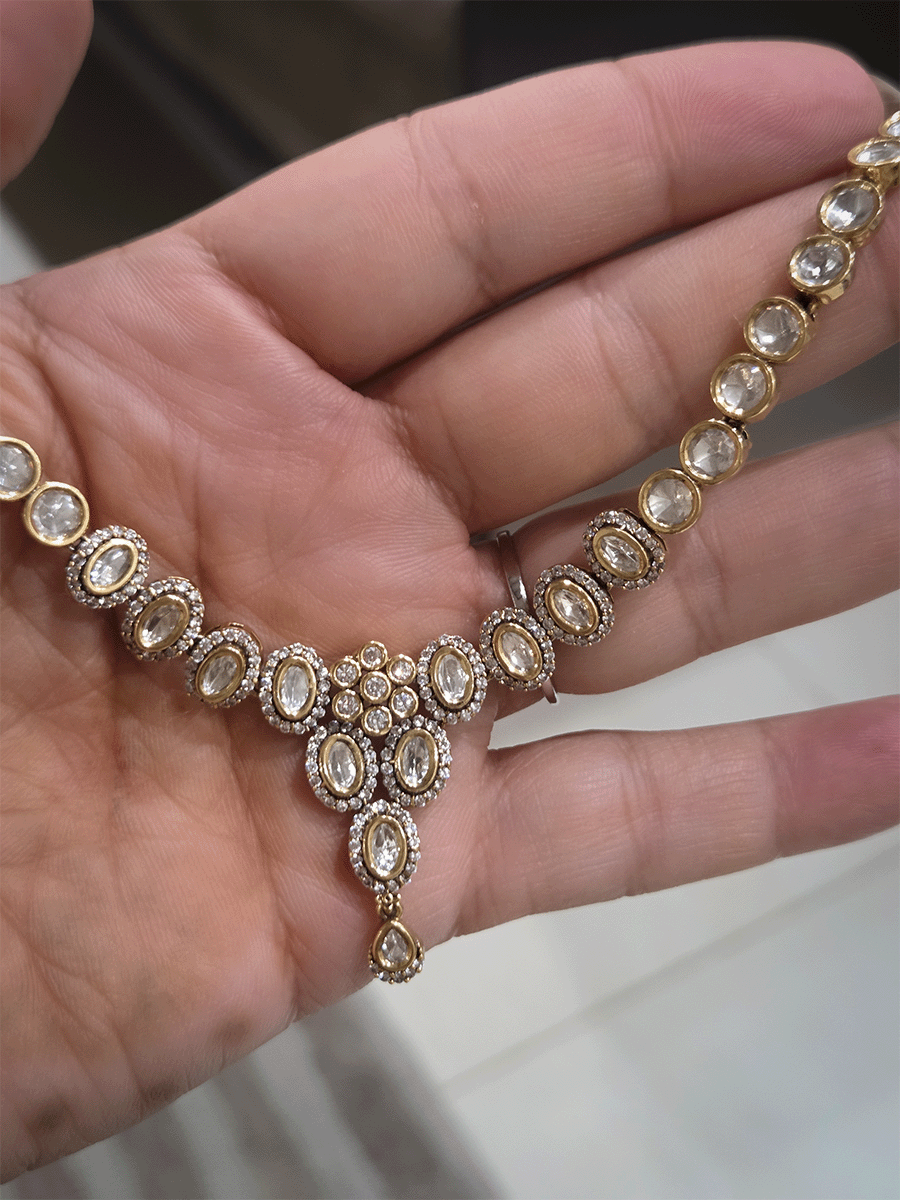 Flower in center of oval moissanite setting sleek antique gold finish set