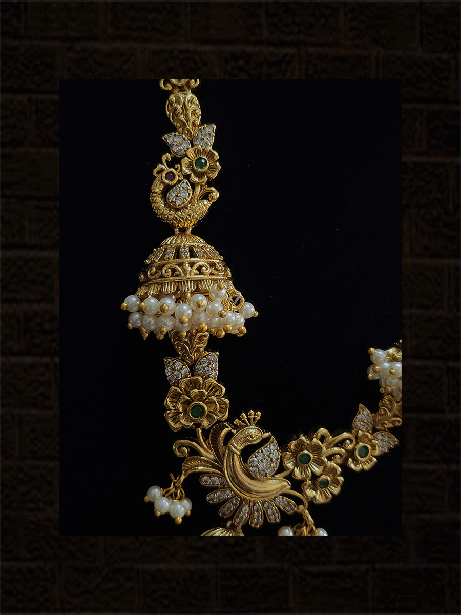 Polki,ruby,green and white stones studded ganpatiji pendant set with flowers and peacocks design