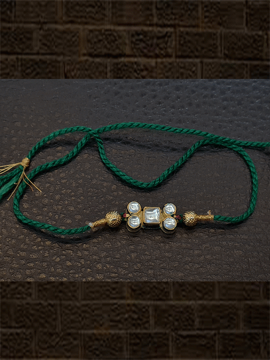 Kundan rakhi with gold bead in red and green thread - Odara Jewellery