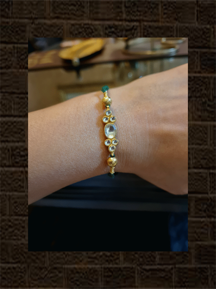 Elegant kundan rakhi in red and green thread with side gold beads - Odara Jewellery