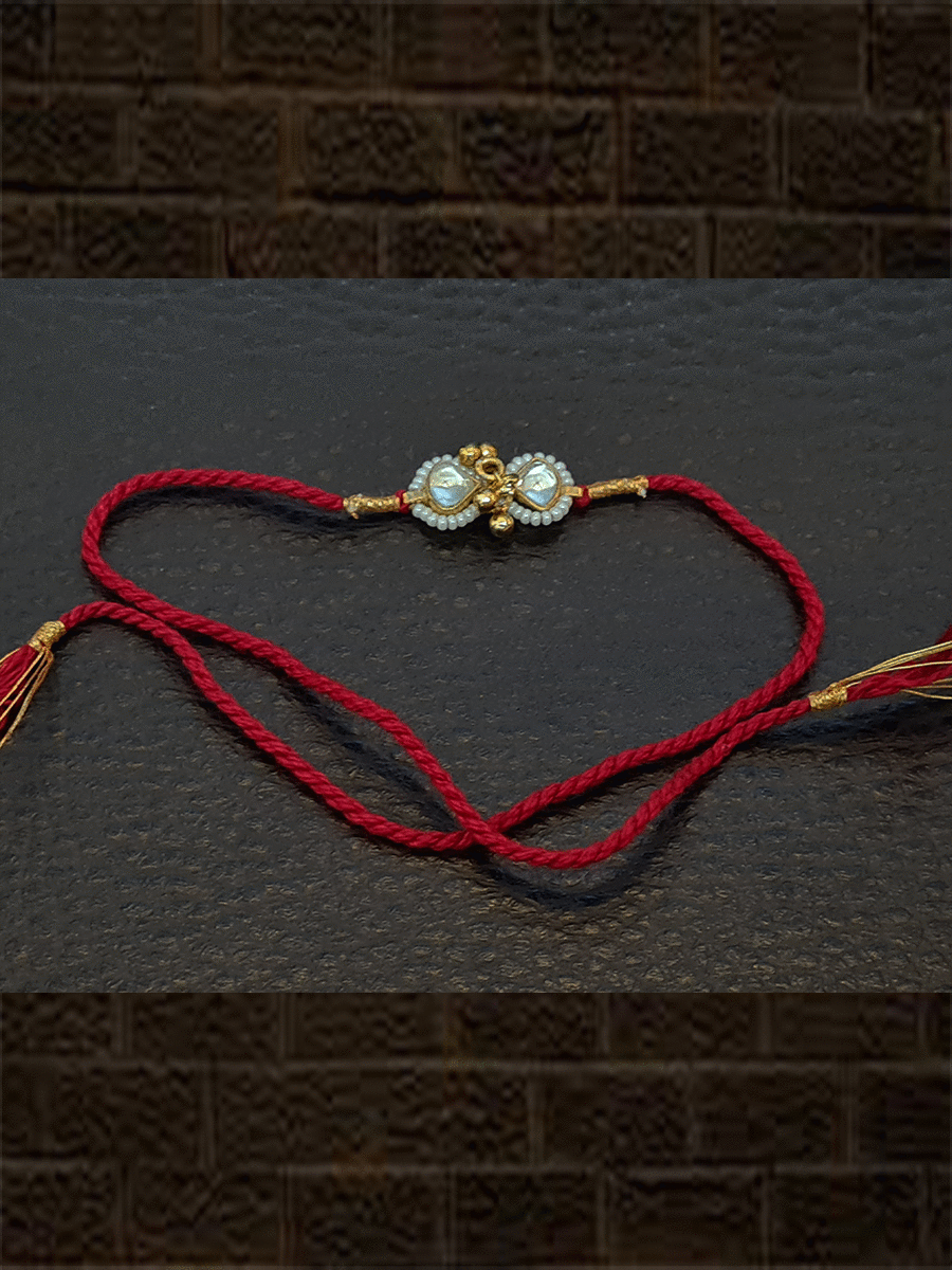 Triangular kundan with ghunghru and pirohi work red thread rakhi - Odara Jewellery