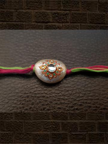 Hand painted white bead rakhi with kundan stone in green and pink thread - Odara Jewellery