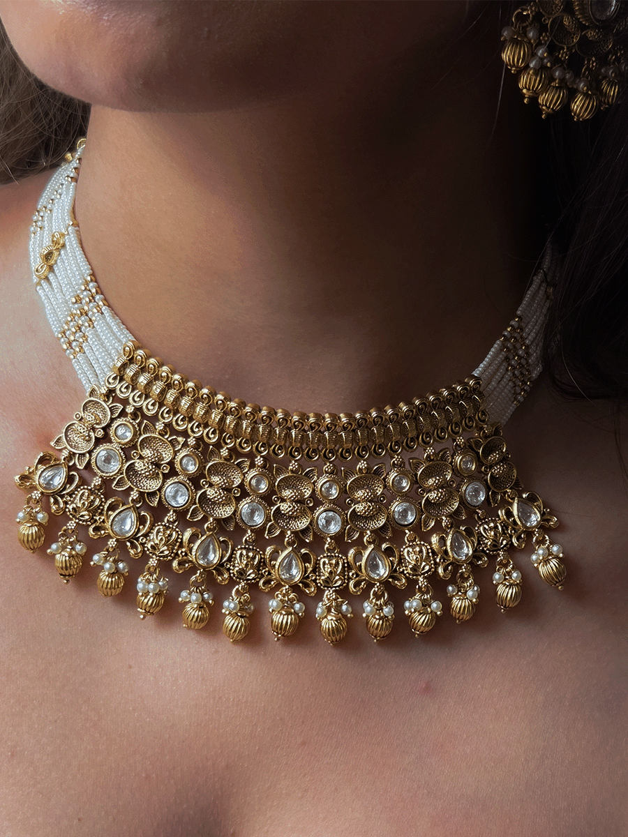 Intricate oval design kundan studded side cheed strings with golden tukdies set