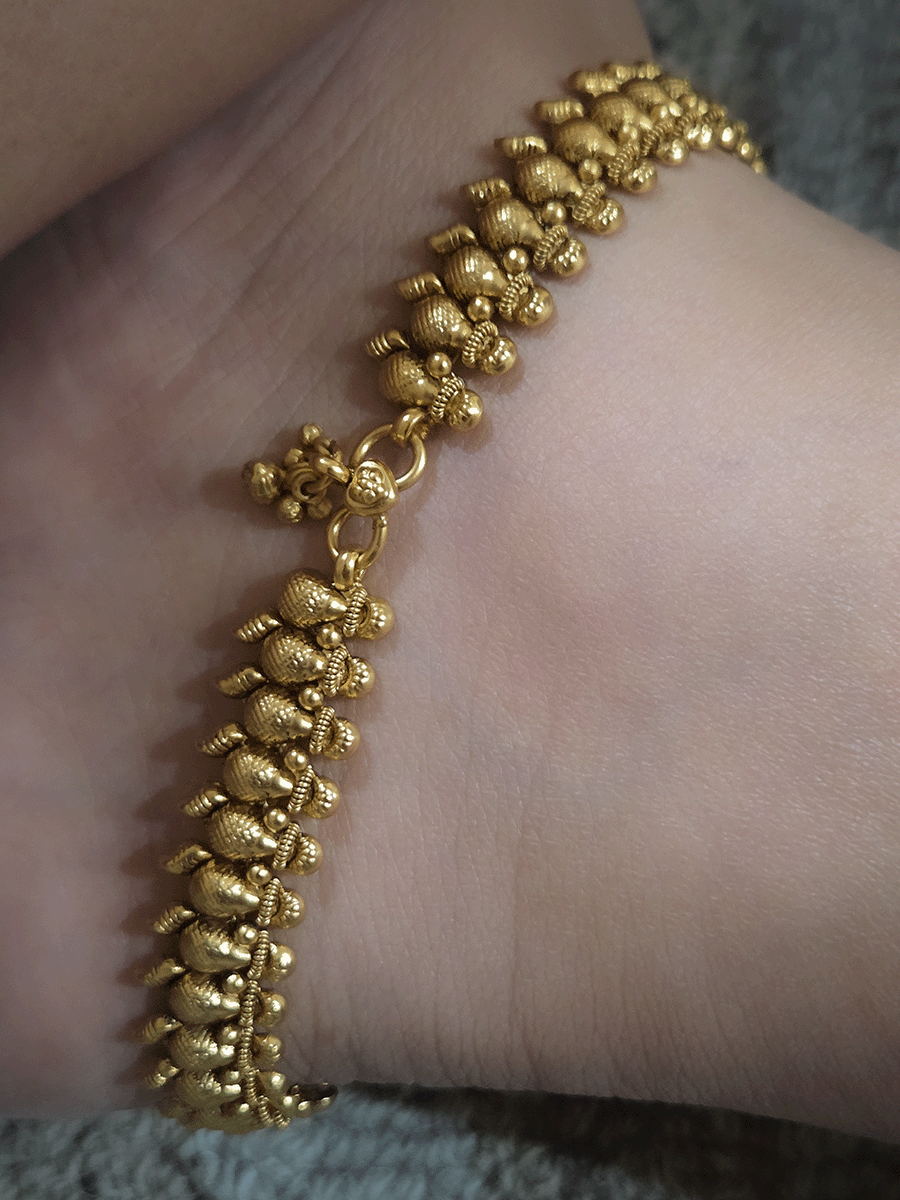 Gold bead top with leaf attached at the bottom of leaf shaped gold bead chain anklets