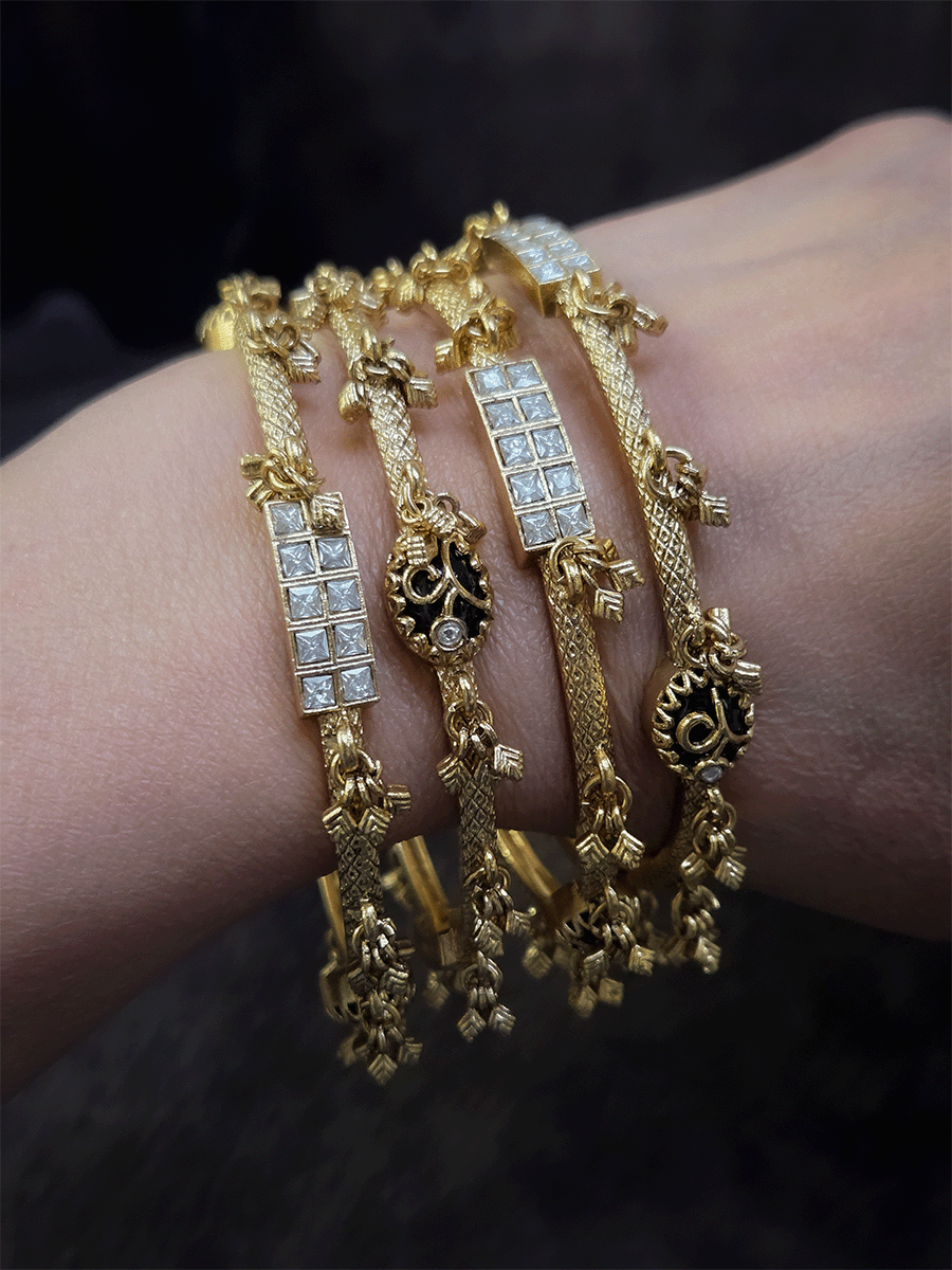 Set of four non-openable ghunghru hanging bangles with inlay work on oval green stone