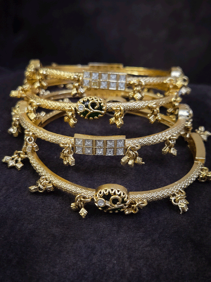 Set of four non-openable ghunghru hanging bangles with inlay work on oval green stone