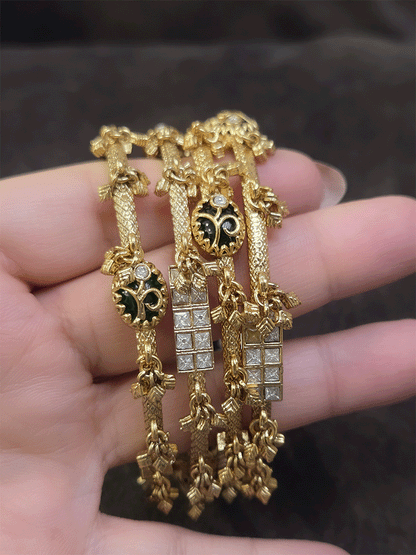 Set of four non-openable ghunghru hanging bangles with inlay work on oval green stone
