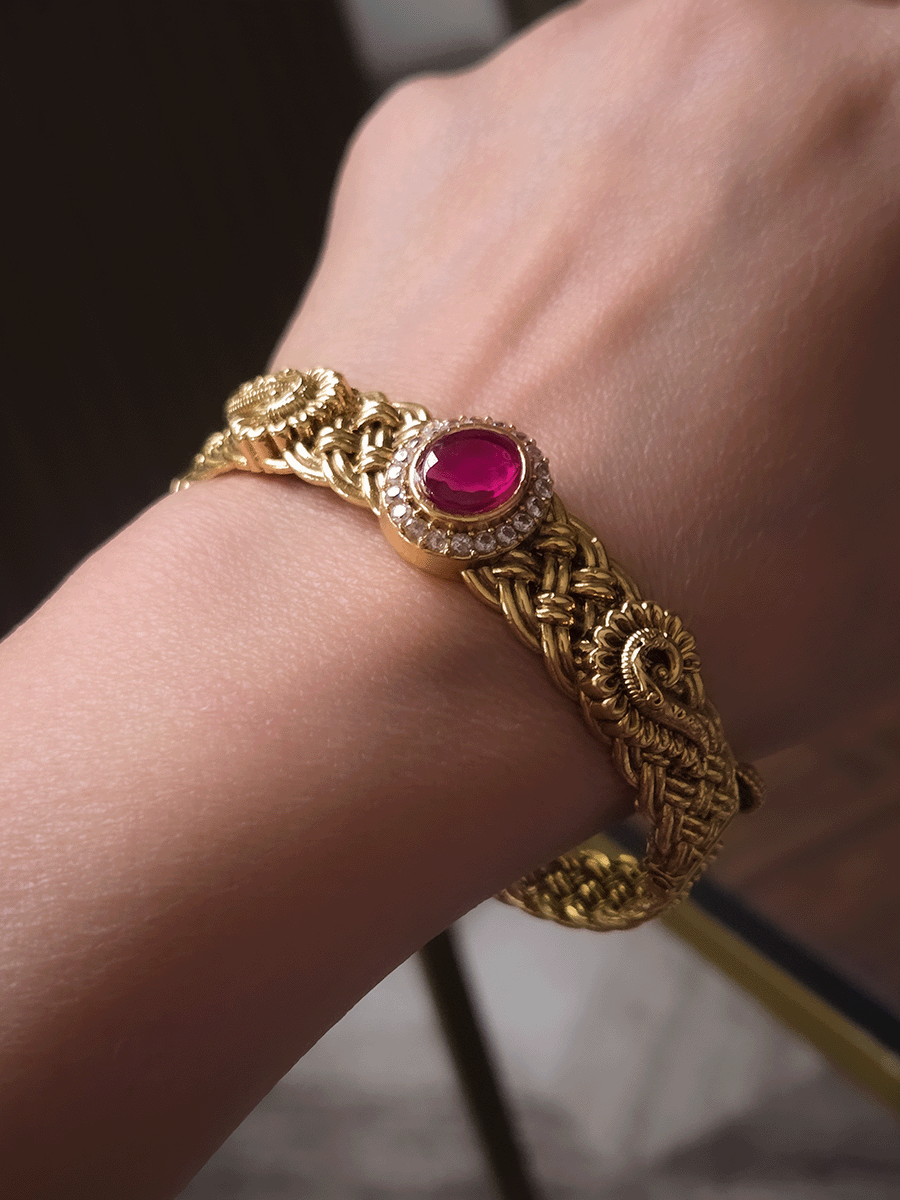 Single openable braid design kada with oval ruby stone center and peacock design on sides