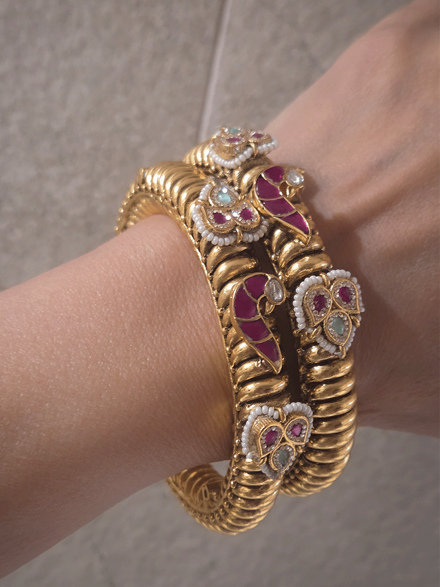 Set of two openable gold plated katas with peacock and three leaf ruby and aqua tukdies