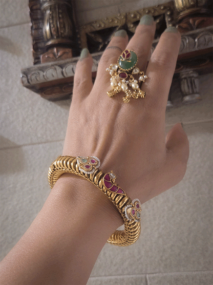 Set of two openable gold plated katas with peacock and three leaf ruby and aqua tukdies