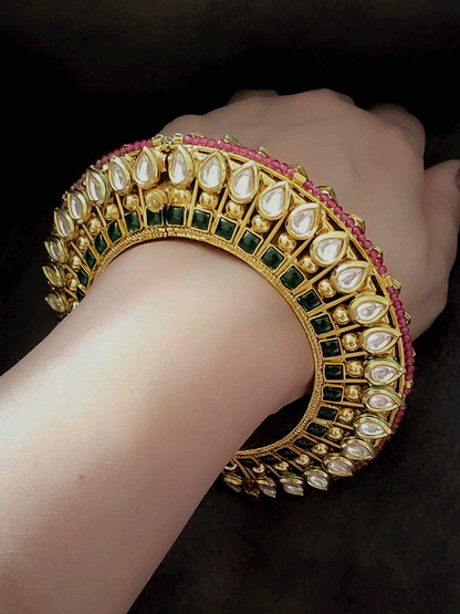 Set of two tear drop shaped kundan kada's with green stones line on the sides with ruby beads pirohi openable pacheli's