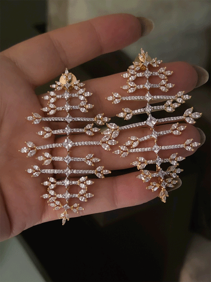 Straight horizontal zircon studded lines with three leaf design at the ends long gold finish flexible earrings