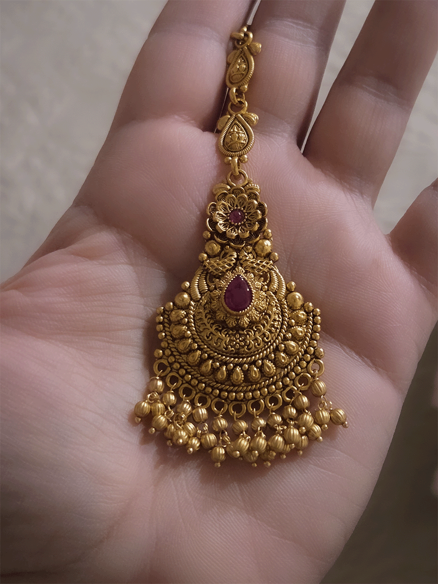 Tear shaped ruby stone center with flower top design maangtika with gold bead hangings