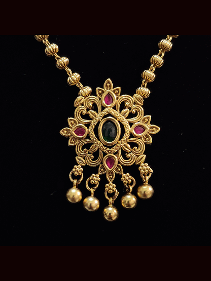Ruby and green stones studded pendant set in gold bead chain