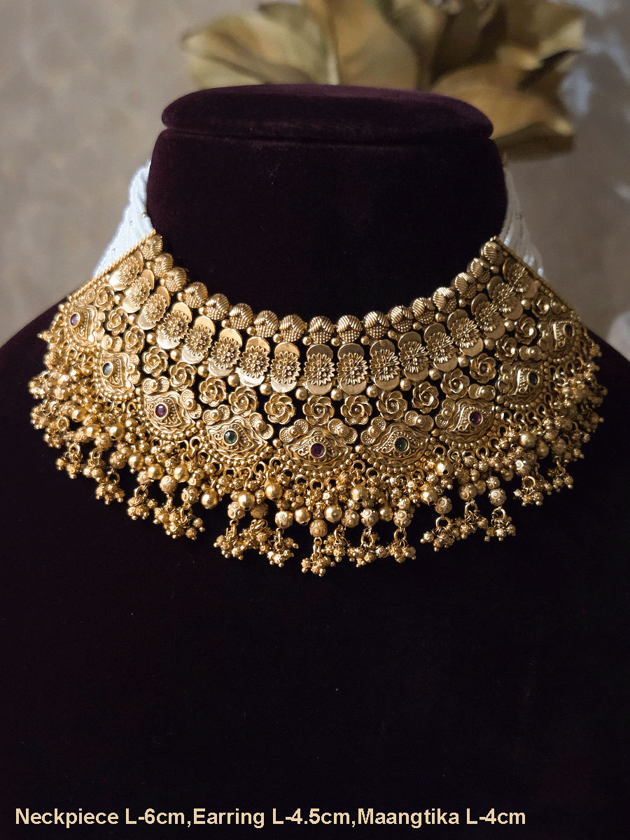 Intricate flower design ruby and green stones studded set with side cheed strings