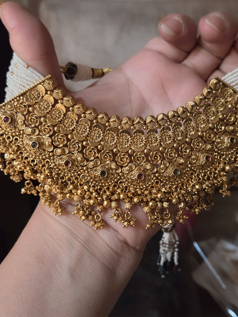 Intricate flower design ruby and green stones studded set with side cheed strings