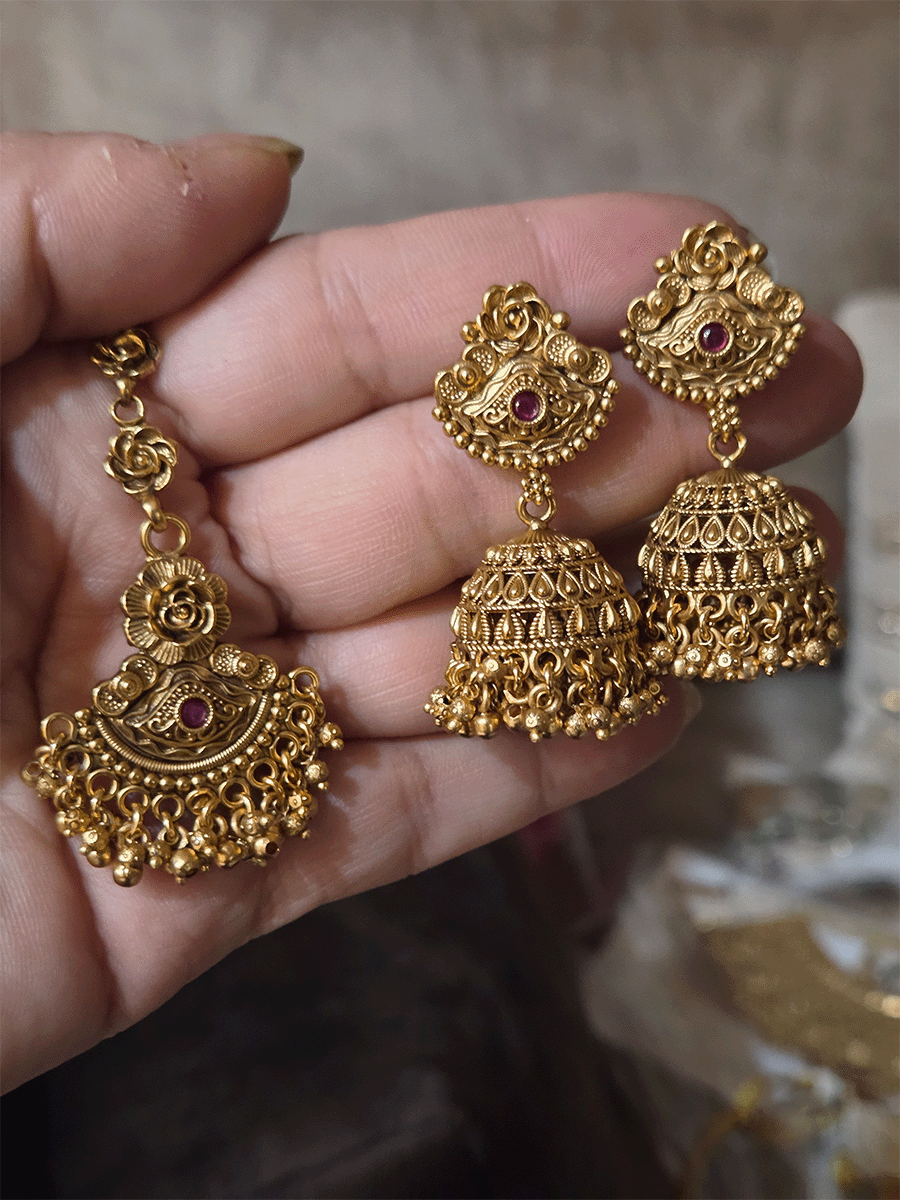 Intricate flower design ruby and green stones studded set with side cheed strings