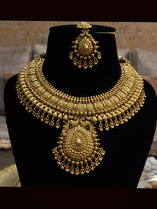 Broad circular design with ghunghru hanging gold finish set and leaf design tukdi in the center