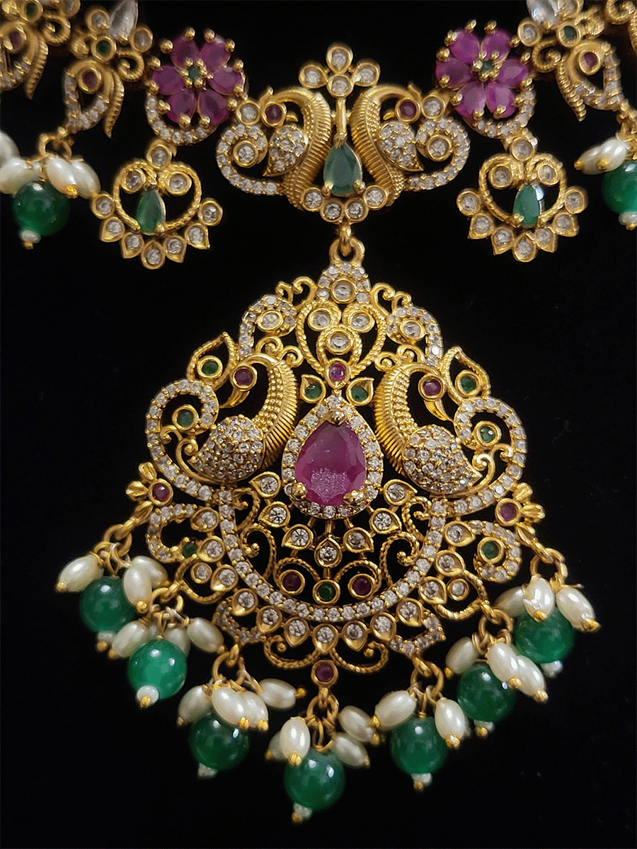 Peacock design pendant set studded with ruby and green stones and green bead drops