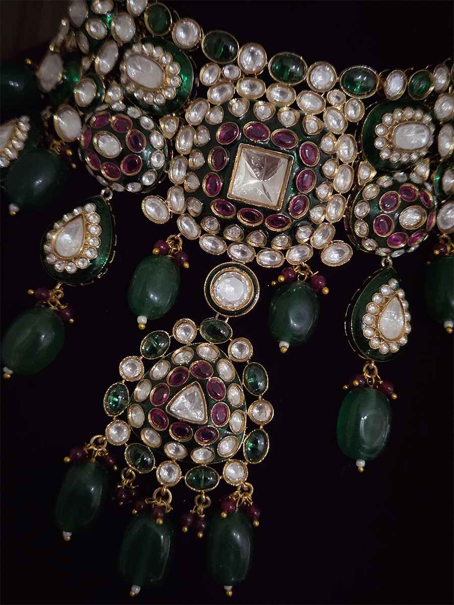 Green and ruby stones studded uncut polki broad set with big leaf shaped tukdi in center and four tear drop tukdies on sides