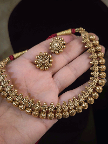 Flower engraved on gold bead design set with maroon dori