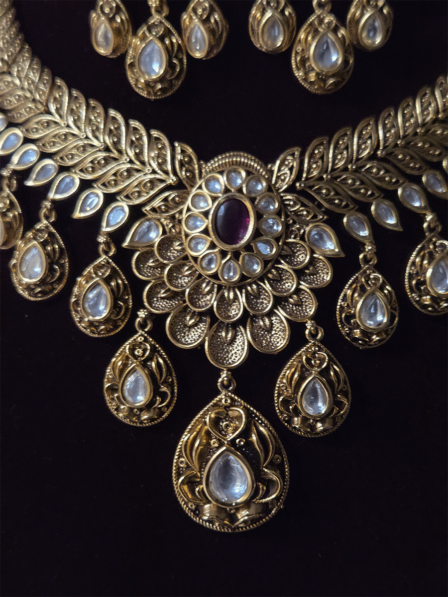 Oval ruby stone with tear shaped kundan drops connecting leaf tukdies kundan set