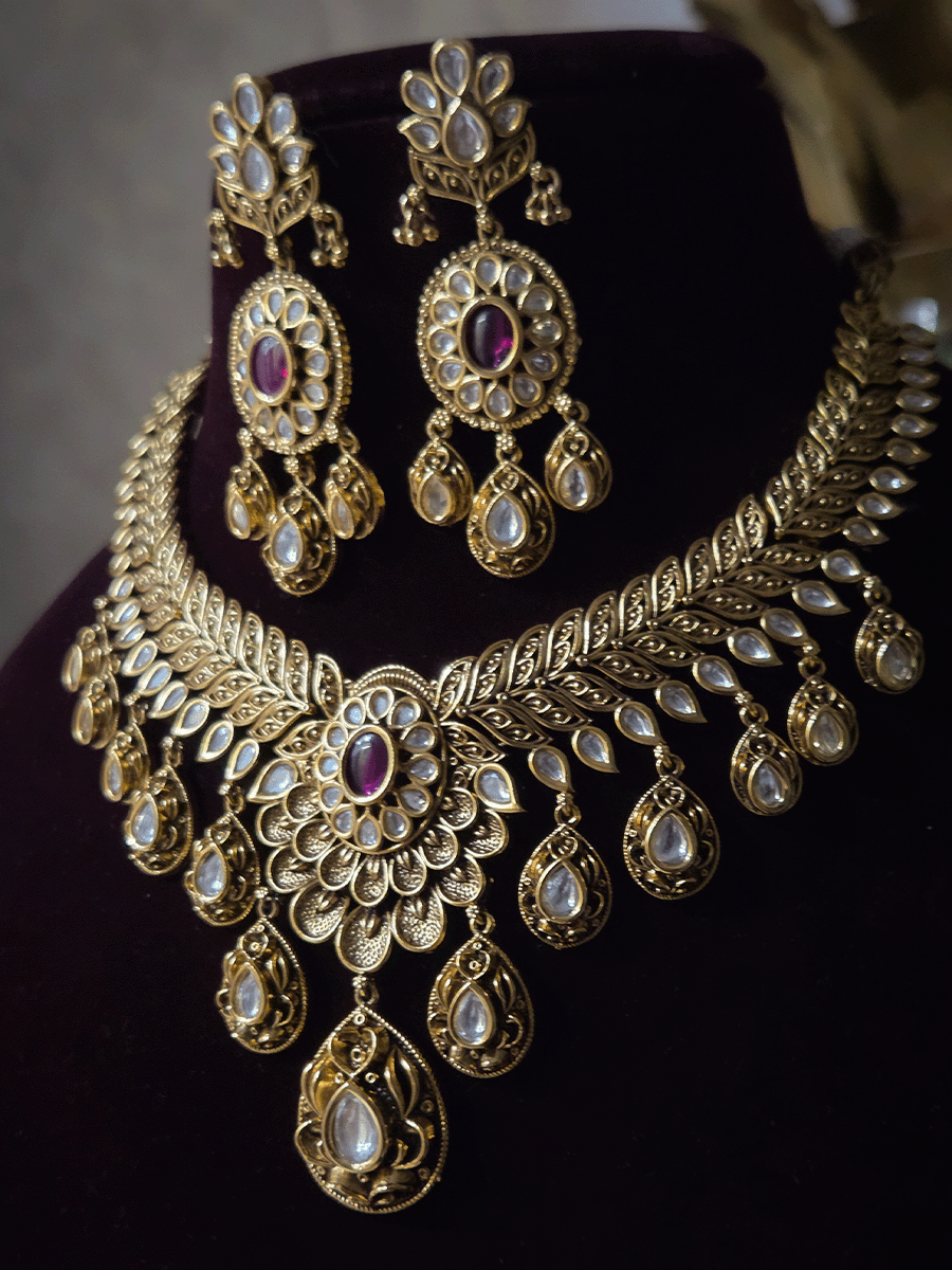 Oval ruby stone with tear shaped kundan drops connecting leaf tukdies kundan set