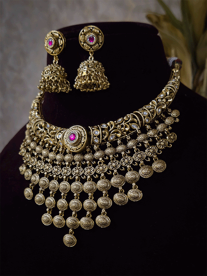 Intricately carved kundan studded hasli set with ruby stone in center and oval design tassels