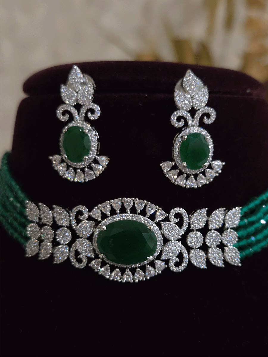 Oval coloured stone in center with AD leaf design and onyx side strings set