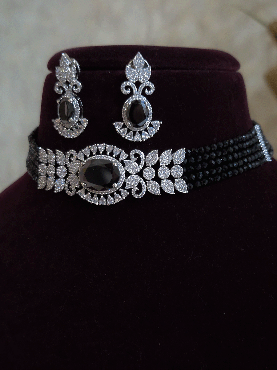 Oval coloured stone in center with AD leaf design and onyx side strings set