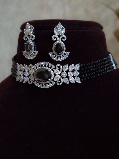 Oval coloured stone in center with AD leaf design and onyx side strings set