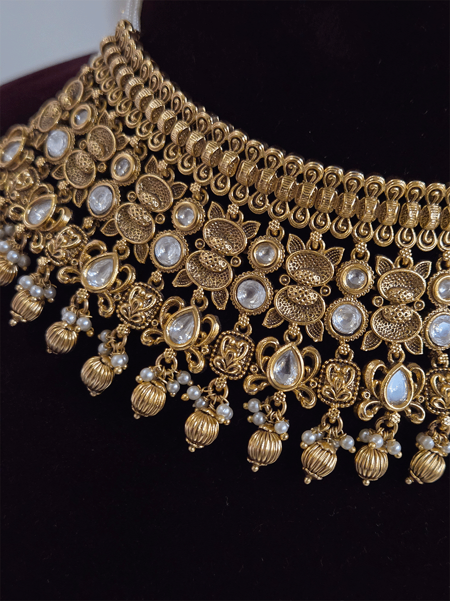 Intricate oval design kundan studded side cheed strings with golden tukdies set