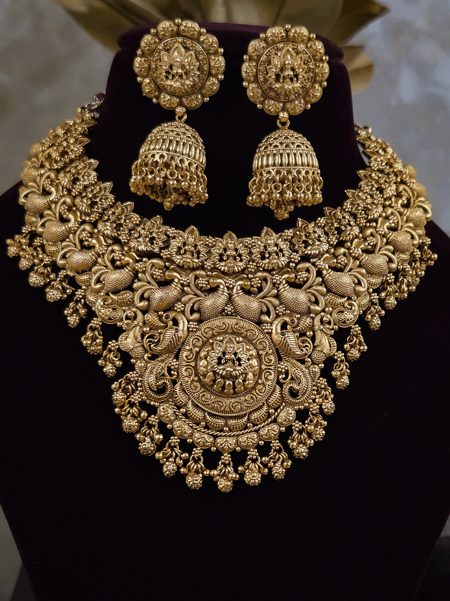 Laxmiji motif in circular design center and on neckline of peacock design broad set with ghunghru hangings