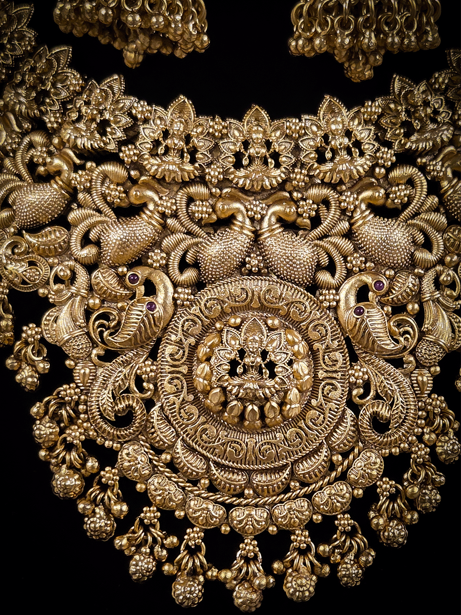 Laxmiji motif in circular design center and on neckline of peacock design broad set with ghunghru hangings