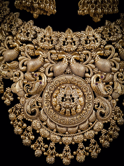 Laxmiji motif in circular design center and on neckline of peacock design broad set with ghunghru hangings