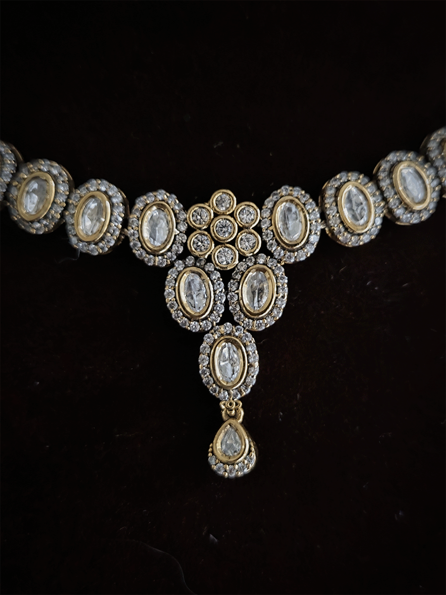 Flower in center of oval moissanite setting sleek antique gold finish set