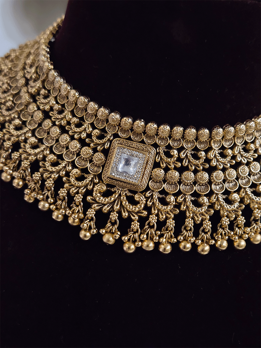 Gold bead lace on top of intricately carved choker set with square kundan in center