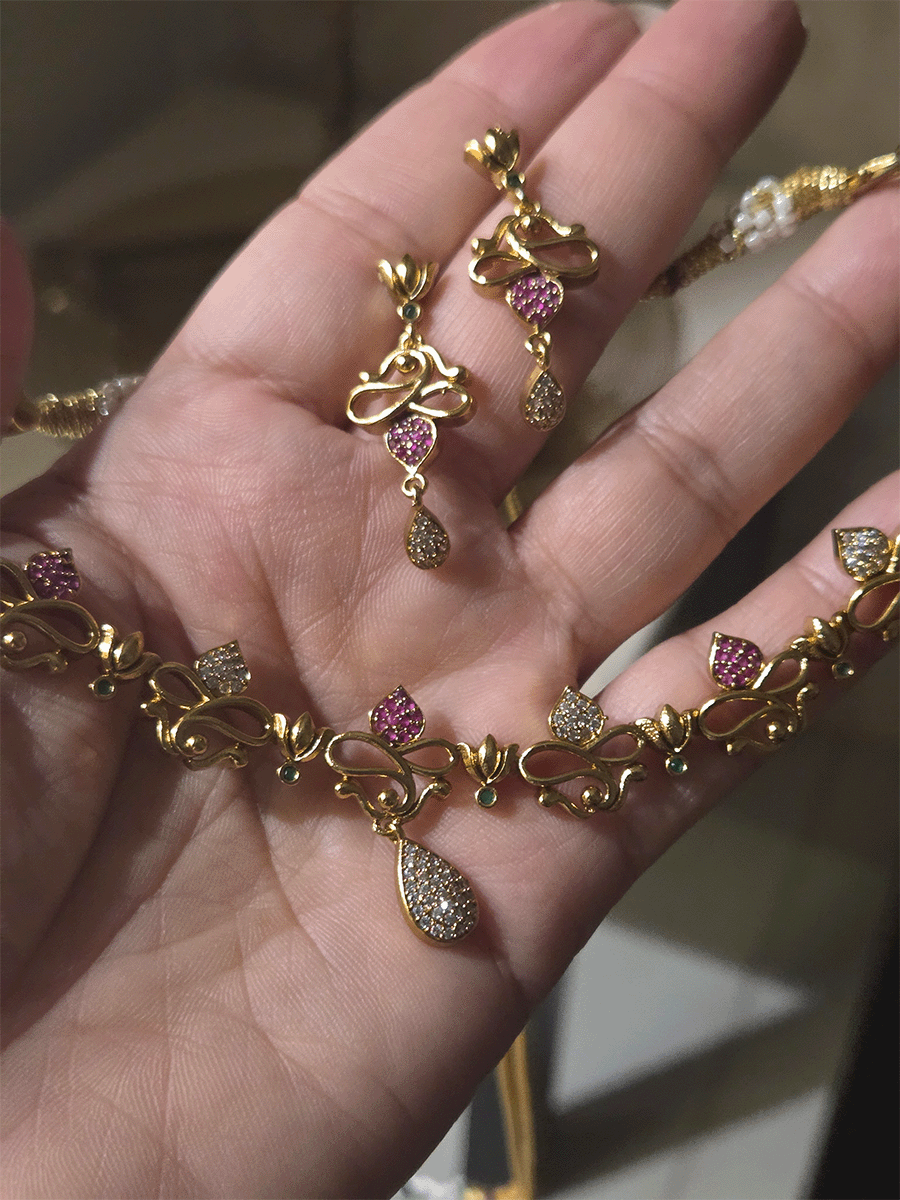 Lotus flower design sleek set with stones studded leaves and tear shaped white stones drop in center