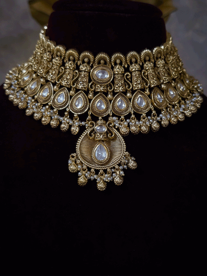 Oval kundan in center of shell ghunghru hangings intricately carved choker set with tear shaped kundan line