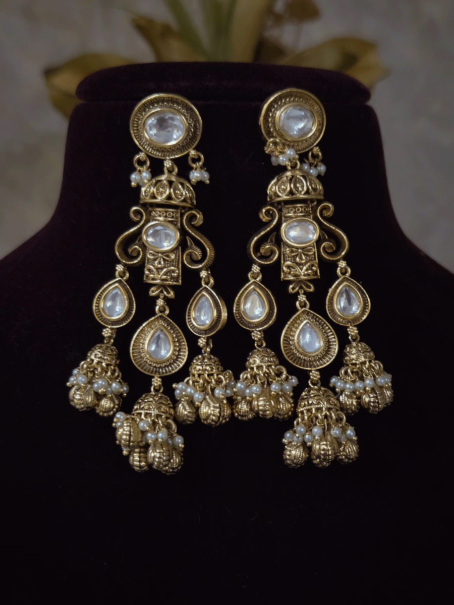 Oval kundan in center of shell ghunghru hangings intricately carved choker set with tear shaped kundan line