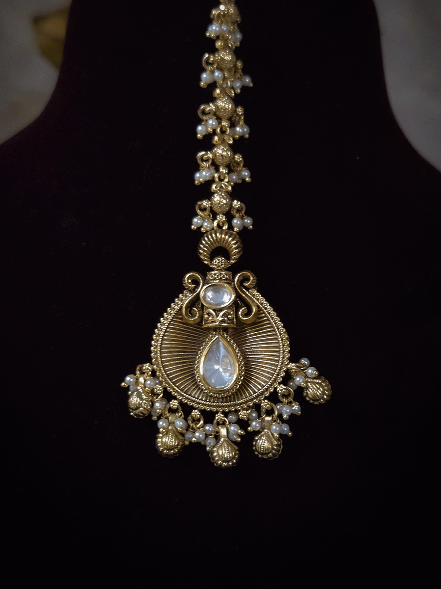 Oval kundan in center of shell ghunghru hangings intricately carved choker set with tear shaped kundan line